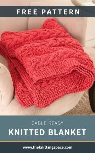 a red knitted blanket sitting on top of a white chair