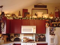 a kitchen decorated for christmas with lights and decorations on the top shelf above the stove