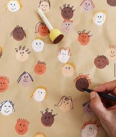 someone is drawing faces on the fabric with a brush