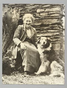 an old black and white photo of a woman with two dogs