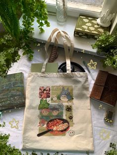 a tote bag sitting on top of a table next to some books and plants