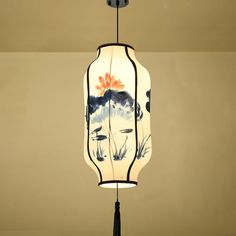 a lamp hanging from the ceiling with flowers painted on it's lampshade