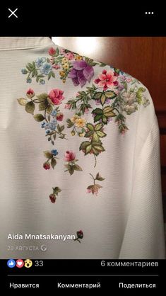 the back of a white shirt with flowers on it