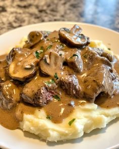 a white plate topped with mashed potatoes covered in gravy