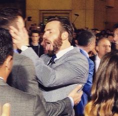 a man in a suit is hugging another man