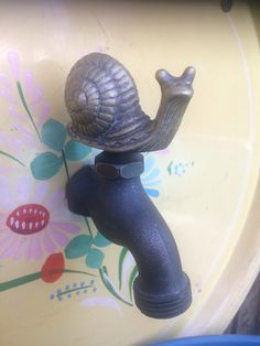 a sink faucet with a snail on it