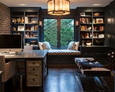 a home office with built - in bookshelves, desk and bench next to a window