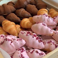 a box filled with lots of different types of pastries on top of each other