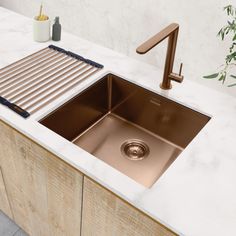 a kitchen sink with a drainer, faucet and soap dispenser