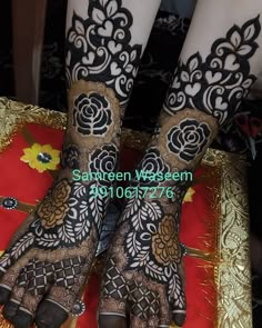 the legs and feet of a woman with henna tattoos on their hands, decorated with flowers