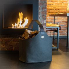 a bag sitting in front of a fireplace with fire coming out of the oven behind it