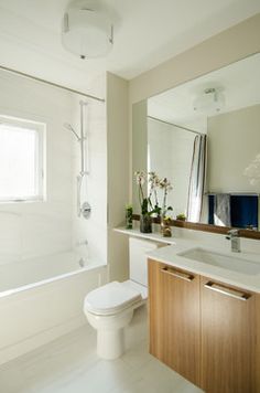 a bathroom with a sink, toilet and bathtub next to a window in it