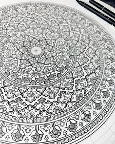 a pen and ink drawing on paper with an intricate design