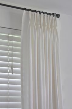 white curtains hanging on the side of a window