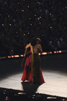 two women embracing each other on stage in front of an audience