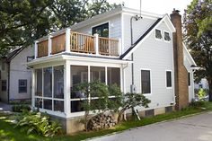 a white house with two balconies on the second floor and an upper deck