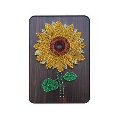 a crocheted sunflower on a wooden surface with beads and bead work