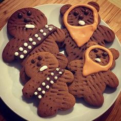 some cookies are on a white plate and have icing in the shape of bears