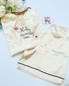 Congratulations of your upcoming wedding/event. These gorgeous, personalised champagne silk pjs have been designed with brides in mind but of course can be fully personalised to your requirements. Each set will include a button up top which will ensure your hair/make up will not be affected by removal of the garment and elasticated waist shorts/trousers. The pyjamas - With a range of sizes they are suitable from age 1 up to age 13. The sizing is standard to the age, and I recommend buying the ag White Sets For Bridesmaid Gift, Bridal Pjs, Silk Pjs, Girls Pjs, Gifts Bridesmaid, Wedding Theme Colors, Flower Girl Gifts, Girls Pajamas, Wedding Night