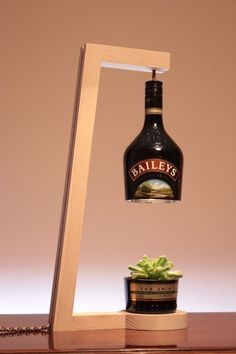 a bottle that is sitting on top of a wooden shelf next to a potted plant