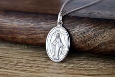 Medium size Miraculous Medal, Sterling silver Our Lady of Grace pendant, Miraculous Medal charm, Detailed Miraculous Medal from Medjugorje This beautiful Miraculous Medal is made with coin technology which makes medal very precise and rich with details. Edge of medal is diamond cut so it gives it very nice shiny look in meanwhile centerpiece is satiated to ensure high fine details come more to expression. Each medal is rhodium plated so it doesn't tarnish or change color. Size of medal is 20 x 1 Silver Miraculous Medal Jewelry As Gift, Our Lady Of Medjugorje, Our Lady Of Grace, Pearl Rosary, Our Lady Of Sorrows, Saints Medals, Rosary Catholic, Miraculous Medal, Rosary Beads