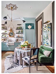 the dining room is decorated in shades of blue, green and white with gold accents