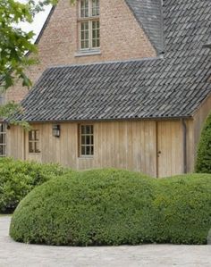 the house is made out of wood and has a large garden in front of it