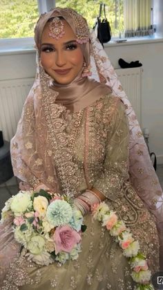 a woman in a bridal gown sitting on a bed holding a bouquet of flowers