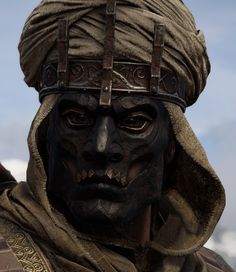 a close up of a person wearing a costume and headgear with an evil look on his face