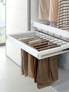 an open drawer with clothes hanging from it