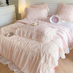 a bed with pink comforters and pillows on it