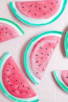 watermelon slices painted on white paper with green trim around them and one slice cut in half