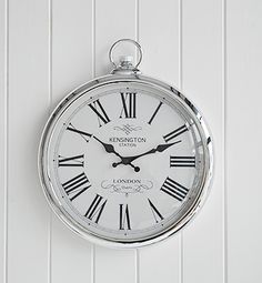 a clock hanging on the wall with roman numerals