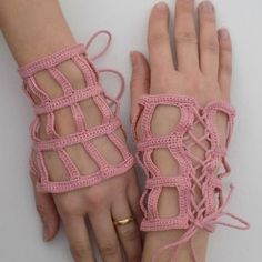 two hands wearing pink crocheted bracelets