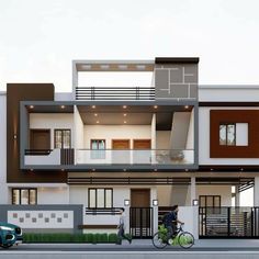 a person riding a bike in front of a two story house with balconies