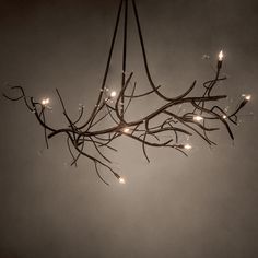 a chandelier with lights hanging from it's branches in front of a dark sky