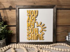 an art print with the words you are my sunshine shine on it next to some beads