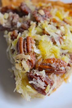 a slice of pecan pie on a plate with nuts and coconut toppings, ready to be eaten