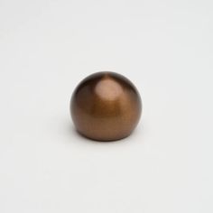 a brown ball sitting on top of a white surface