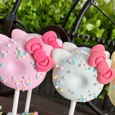 three hello kitty lollipops on sticks with sprinkles