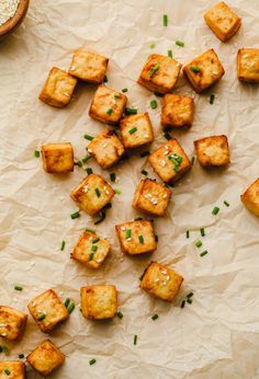 tofu cubes with chives and sesame seeds on parchment paper