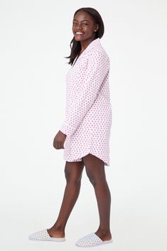 You sleep better in cute pajamas — it's science. The Perlita Lounge Dress is a super soft cotton nightshirt with a button front and front pocket. The pink hearts print adds a fanciful touch to a classic sleep style. 6 Buttons Front Patch Pocket Materials and Care 100% Long-Staple Premium Cotton Machine Wash Cold, With Like Colors Do Not Bleach, Tumble Dry Low (Line Dry Recommended) Imported Measurement Information Model Wears Size Small Size S Length: 34.5" (from Shoulder) Size S Sleeve Length: Pink Cotton Nightgown For Overnight, Cotton Fitted Sleepwear For Sleepover, Fitted Casual Sleepwear, Pink Cotton Sleepwear For Overnight, Fitted Cotton Sleepwear For Overnight, Hearts Print, Roller Rabbit, New Heart, Heart Quilt