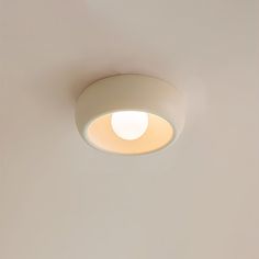 a light that is on the ceiling in a room with white walls and flooring