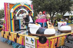 two people sitting on top of a float with guitars and other musical instruments in it