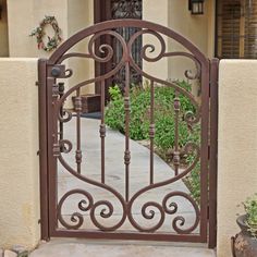 an iron gate is shown in front of a house