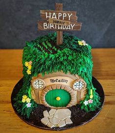 a birthday cake made to look like a hobbot house with a happy birthday sign on top