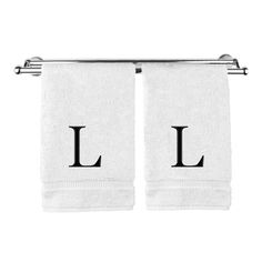 two white towels with the letter l on them hanging from a towel rack in front of a white background