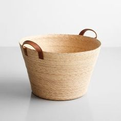 an empty basket with handles on a white surface