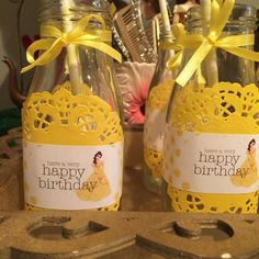 two glass jars with yellow ribbon and tags on them