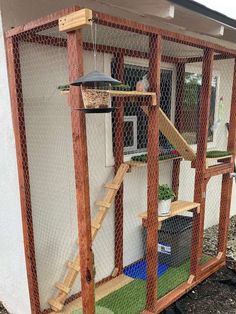 a cat house made out of chicken wire and wood